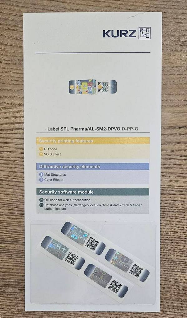 Security label samples with QR codes, optical protection features, and tamper-evident technology for pharmaceutical packaging.